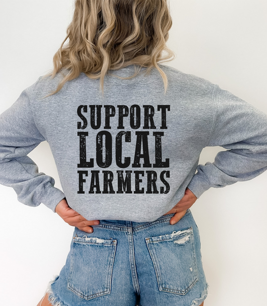 Person wearing a gray sweatshirt with 'Support Local Farmers' text on the back.
