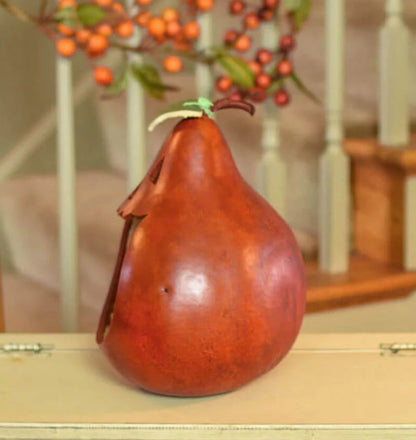 Decorative gourd with a green stem on a wooden surface with blurred background